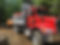 Camion benne rouge et pelleteuse sur un chantier d'excavation.