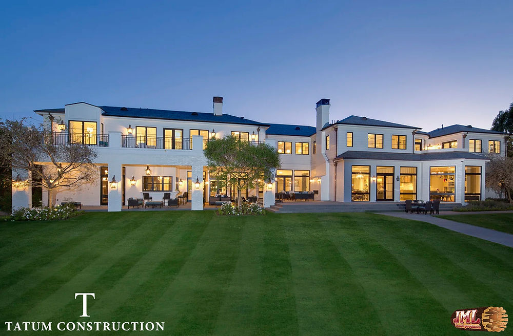 Large modern home viewed from the backyard displaying it's size, modern details, and large windows.