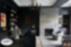 The office with black cabinet walls, black desk, and stone fireplace accompanied with seating area.