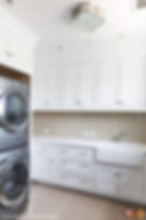 Simplistic laundry room with stacked washer dryer and pan tiled backsplash.