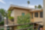 Balcony view of the home highlighting the wood siding and large rectangular windows.