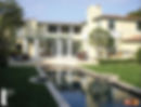The villa's backyard featuring a patio, sunshade, and elongated pool.