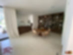 Dining area with wooden bar accented by large backwall bookshelf.