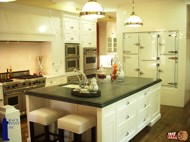Kitchen with stainless steel appliances, white cabinetry, and green countertops.