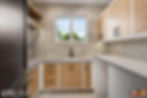 Brown tiled laundry room with warm wood and white cabinets paired with grey counter tops.