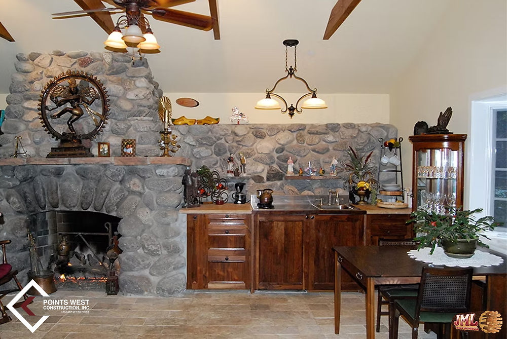 Small traditional style kitchen accompanied with a large stone fireplace and small dining table.
