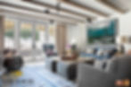 Luxury living room with large sofa area and a drum set with view of backyard area through patio doors.