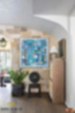 Small living pace with chair, plant, and modern art featuring the home's organic shape.
