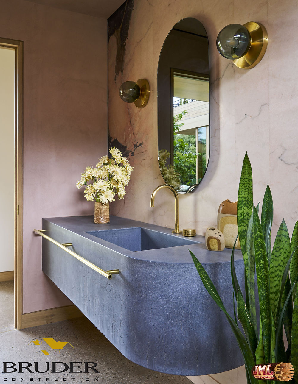 Blue, simple, and geometric bathroom sink paired with oval mirror and large light bulbs.