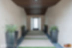 Enclosed walkway of the front entrance to home with wood planked ceiling.