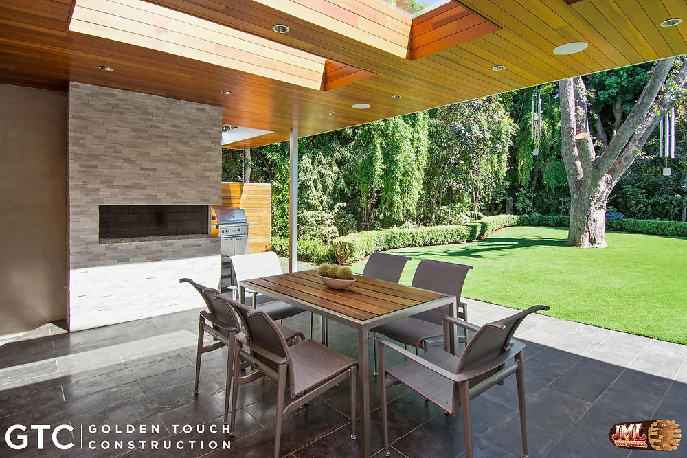 Covered outdoor seating area with fireplace and wood ceilings.