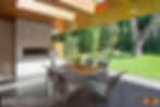 Covered outdoor seating area with fireplace and wood ceilings.