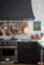Luxury kitchen with hanging pot rack full of all copper pots, pans, and strainers.