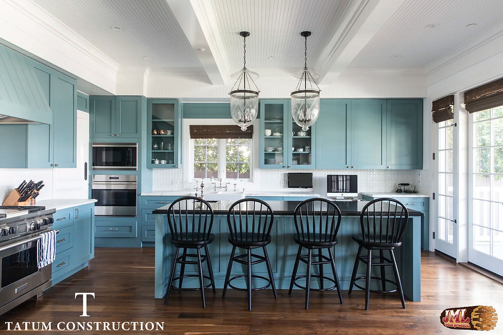 Large muted blue kitchen with dark wood floors and beams across the ceiling.