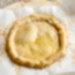 A partially baked pie crust is ready to be filled with pizza toppings.