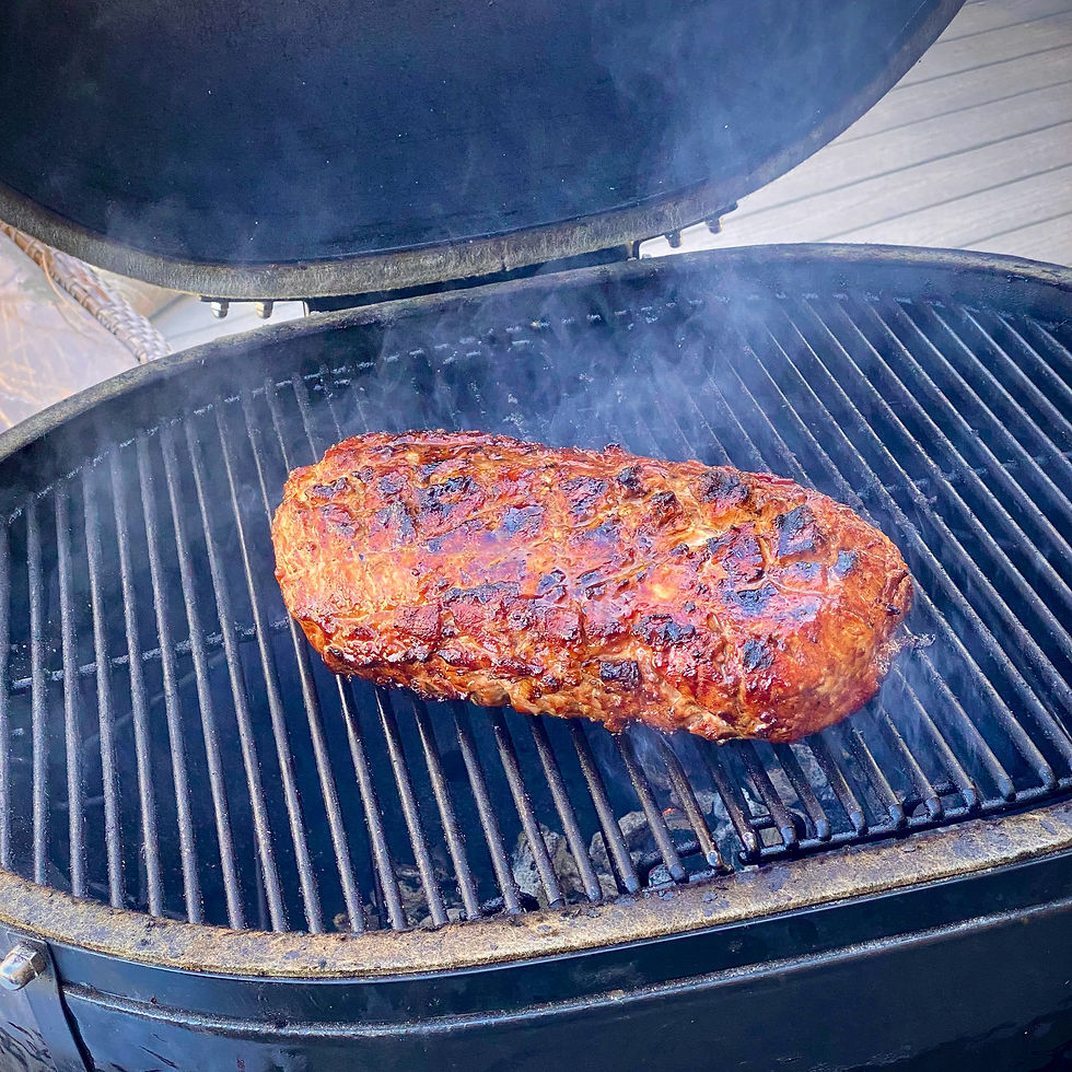 A pork loin that sits on a smoky grill.