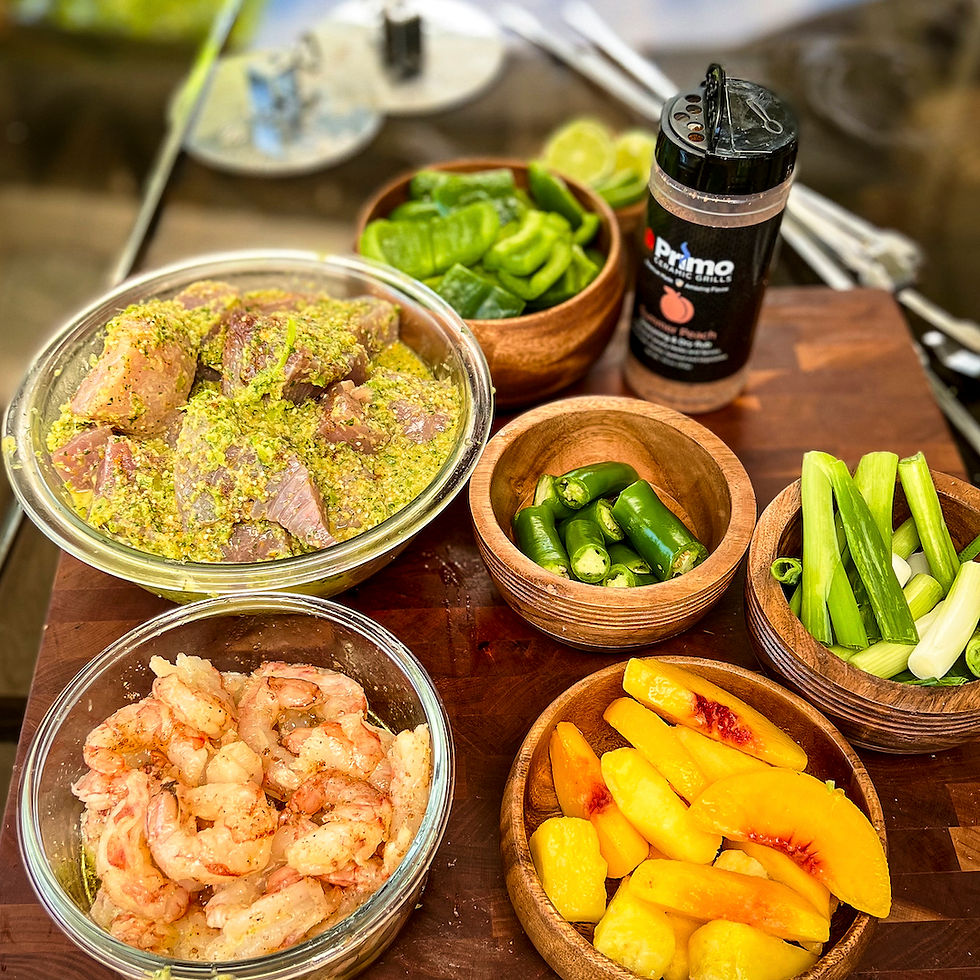 A bowl of fish in a marinade, shrimp, peaches, onions, Primo rub, bell peppers, and Serranos are on a cutting board.