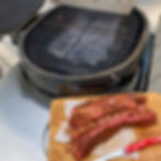 A homemade foil drip pan is in the Primo Ceramic Grill waiting for pork riblets.
