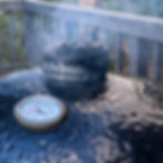 A Primo Ceramic Grill with smoke drifting from the daisy vent.