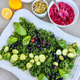 A bed of kale, cucumbers, and basil is ready for salmon.