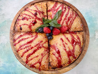 Four razzleberry glazed hand pies tightly tucked onto a round platter.