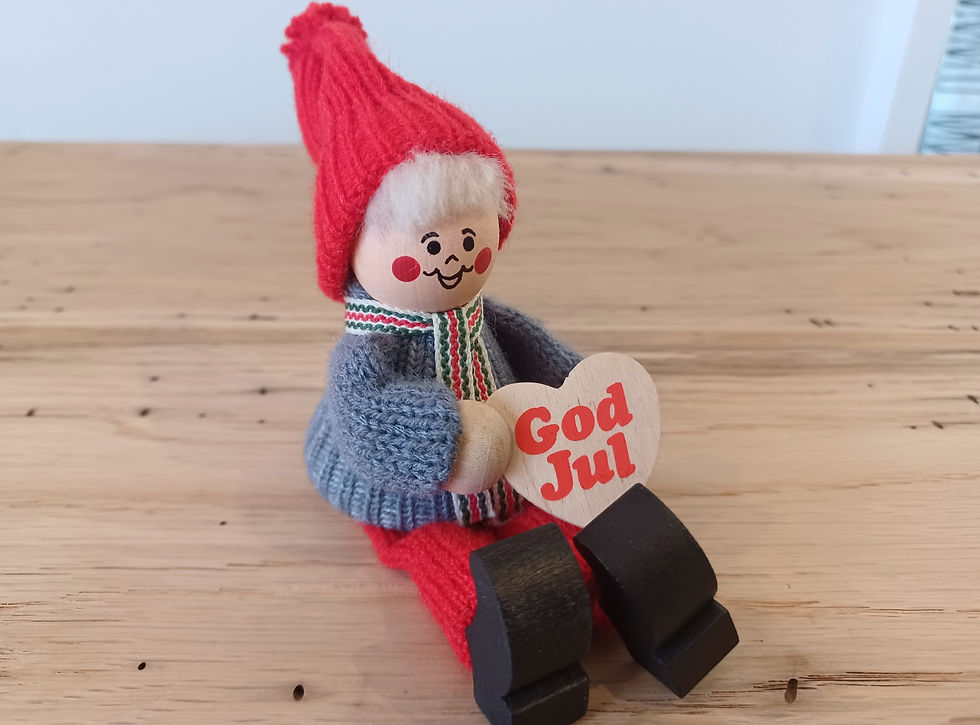 God Julのプレートを持ったニット帽のお洒落なトムテ