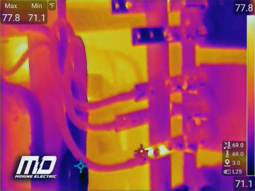 Close-up view of a boat's electrical panel with wires and fuses