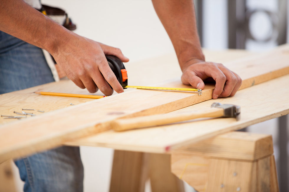 A Central Texas remodeling contractor measuring pieces of wood.