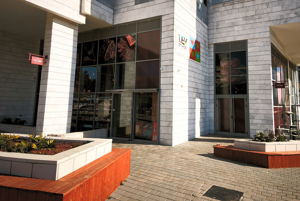 חזית אטליז "הקצב בעיר" בשדרות יצחק שמיר 17 באור יהודה, מצולמת מבחוץ יחד עם המדרכה והרחוב