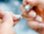 Manicurist using electric nail drill at Toledo hair salon