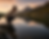 Femme observant son reflet dans un lac de montagne au coucher du soleil, symbolisant l’introspection et la bienveillance envers soi-même