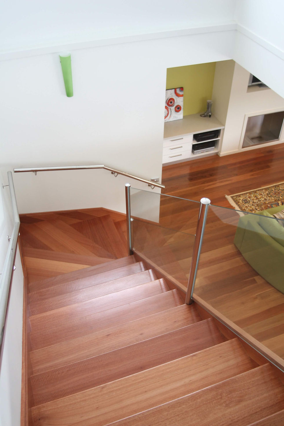 Modern wooden staircase in red gum with glass railing