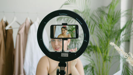 Influencerin filmt sich mit dem Smartphone für Social Media – Symbolbild für Content-Erstellung und steuerpflichtige Umsätze 2025