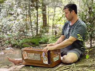 Kevin by river with harmonium.JPG