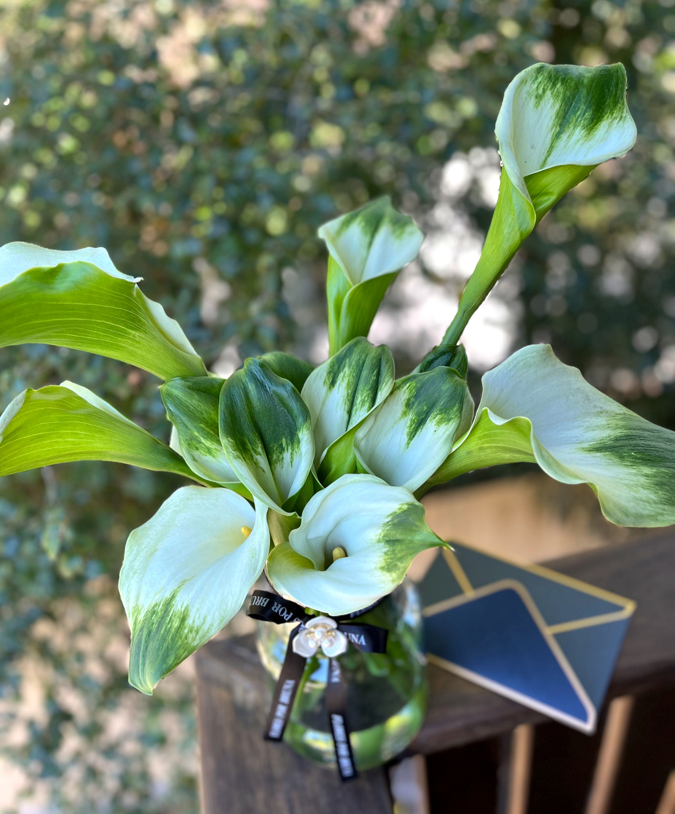 Arranjo Floral em Vaso de Vidro com Copos de Leite