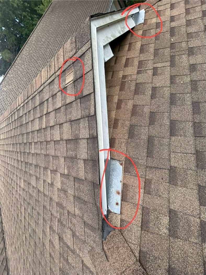 A dormer with flashing that has rusted nails and missing shingles.