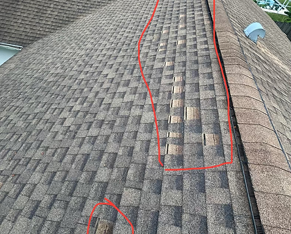 Shingles missing from the top of a roof in Palm Bay.