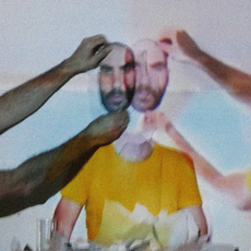 Cena da obra “¿Cómo as coisas chegaram aquí”, de Iván Haidar, com performer de camiseta amarela diante de projeções sobrepostas e gestos corporais em composição visual experimental.