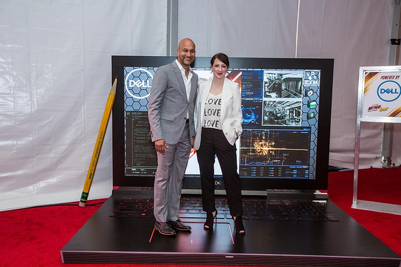 Actors standing on giant Dell laptop