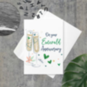 Emerald Anniversary greeting card with champagne glasses and green heart decorations.
