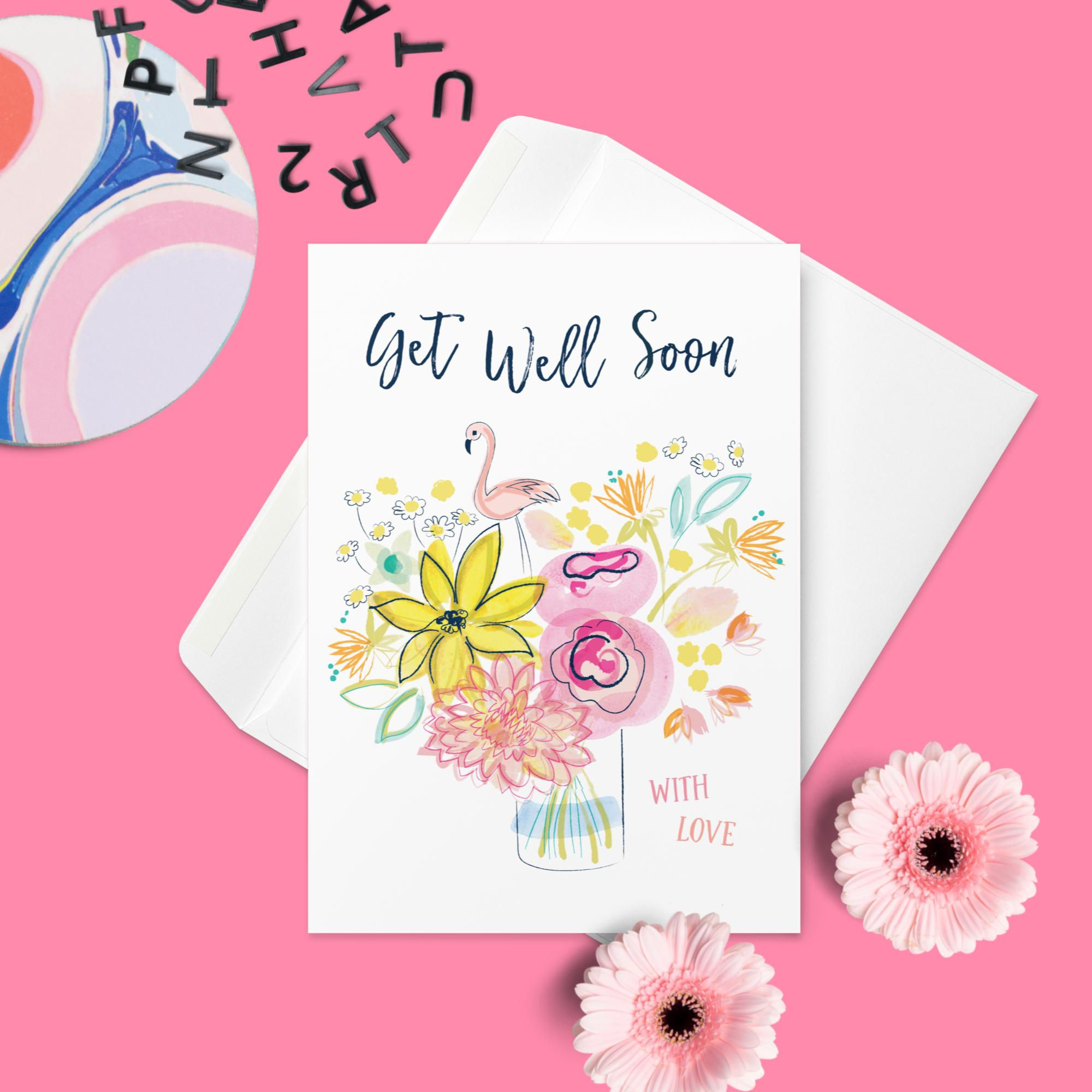 Alt Text and Image Description: Alt Text: "Floral Get Well Soon Card with Flamingo Illustration on a Pink Tabletop.