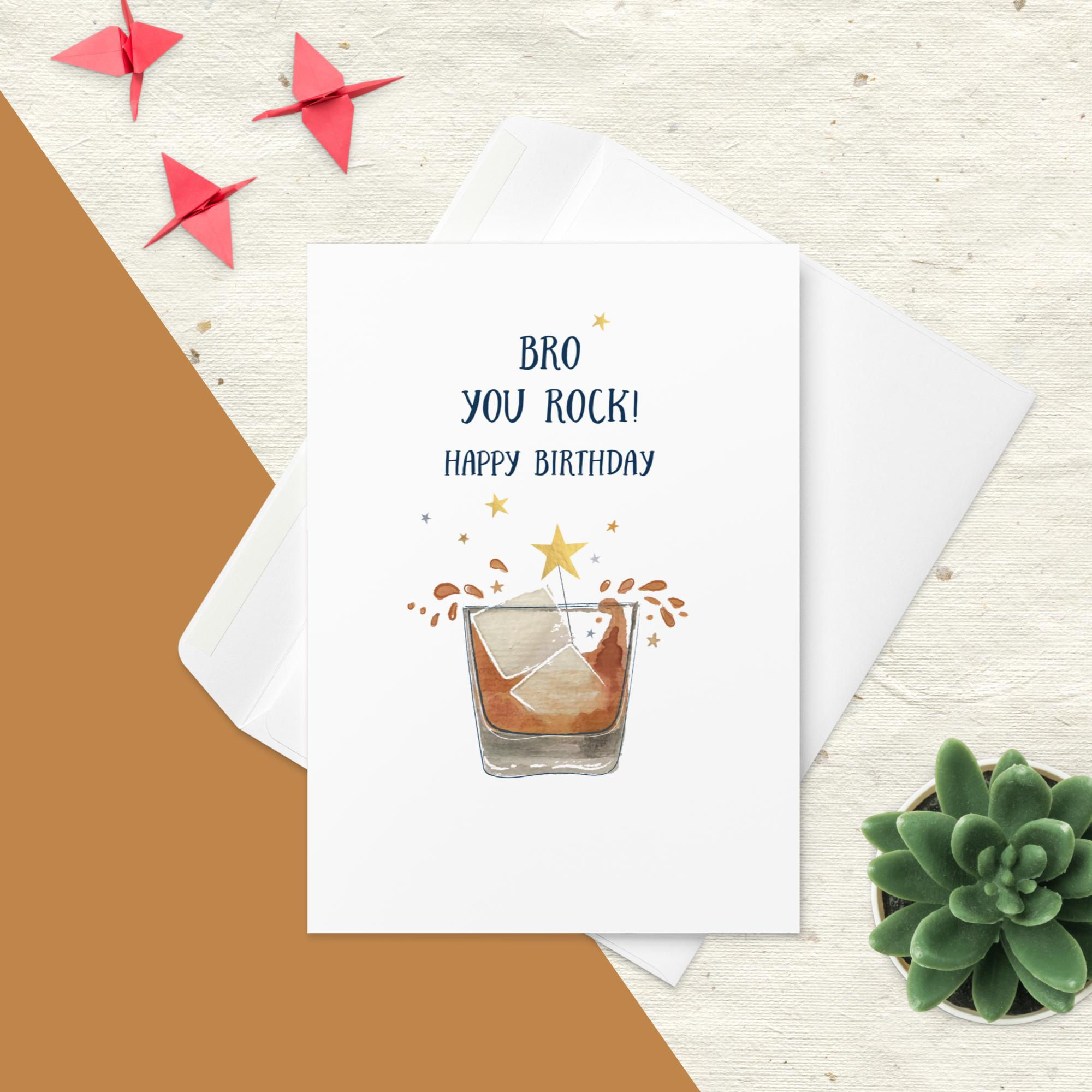 "BRO YOU ROCK! HAPPY BIRTHDAY" card featuring a glass of whiskey with ice and splash design, on a white background.