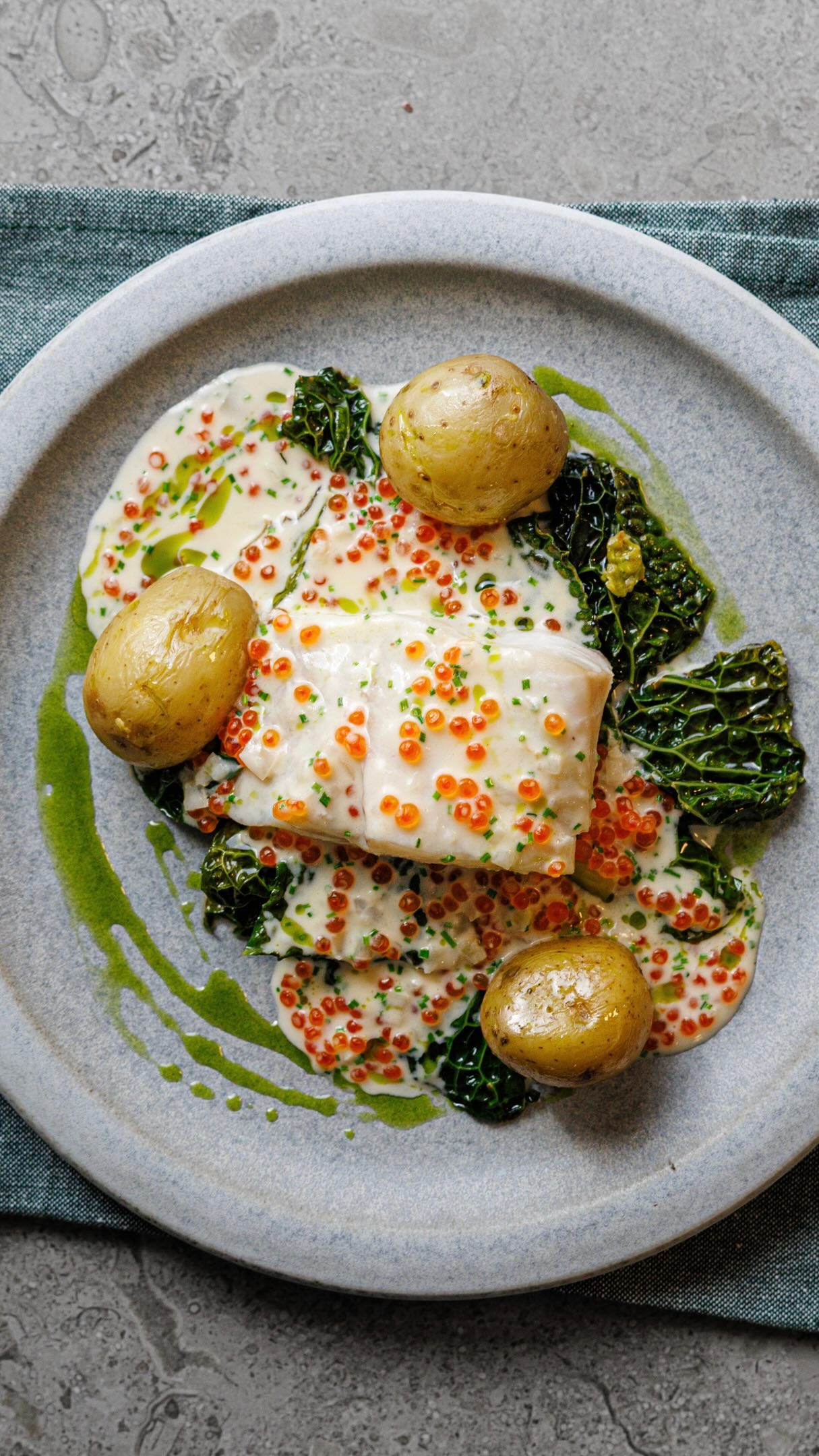 En av mina signaturrätter nu kanske. Norsk sejrygg, vitvinssås med miso, rom och gräslök har blivit en riktig favorit. Serveras med smörig potatis, citronkål och rostad kombuolja.
Ingredienser
10 portioner
Fisk
* 1,5 kg norsk sejrygg, delad i 10 portioner
* 80 g salt + 1 liter vatten
* 25 msk smör
* 2 dl vitt vin
* 10 g ljus sesamolja
Kombuolja
* ½ stort ark torkad kombu
* 5 dl rapsolja
* 80 g babyspenat
* Salt
Potatis
* 1 kg potatis
* Smör och salt efter smak
Vitvinssås
* 30 g smör
* 50 g bananschalottenlök
* 90 g koncentrerad fiskfond
* 400 g vitt vin
* 600 g matlagningsgrädde
* 15–20 g ljus miso
* 150 g regnbågsrom
* 30–50 g finhackad gräslök
Savoykål
* 2 savoykålshuvuden, cirka 1,6–1,8 kg
* 80 g smör
* 20–30 g citronsaft
* Finrivet skal från 1 citron
* Havssalt och vitpeppar
Gör så här
1. Fisken: Blanda salt och vatten. Rimma fisken i ca 20-30 minuter, ta upp och låt rinna av. Lägg i ett bleck med smör, vin och sesamolja. In i ugn på 80C med 50 % ånga till fiskens innertemperatur är 50C.
2. Kombuoljan: Rosta kombun på 225 °C i 10–15 minuter tills den är brun och spröd. Bryt i bitar och mixa med oljan i kannmixer till 80 °C. Tillsätt spenat och salt, mixa på full hastighet i 1 minut och sila utan att pressa.
3. Potatisen: Koka i saltat vatten. Slunga med smält eller brynt smör och smaka av med salt.
4. Såsen: Hacka löken och fräs i smöret utan att den tar färg. Tillsätt vin och fond, reducera till hälften. Häll i grädden, mixa slätt och sjud i cirka 10 minuter. Smaka av med miso. Vänd ner rom och gräslök precis före servering.
5. Kålen: Ta bort roten och skär kålen i bitar. Ånga kålen tills den är mjuk med lite spänst. Vänd med smält smör, citronsaft, citronskal, salt och peppar. Färdigt att servera 💙