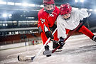 Two young hockey players competing on an ice rink