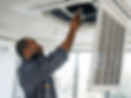 Image of a man using a screwdriver to repair an HVAC system in a commercial building