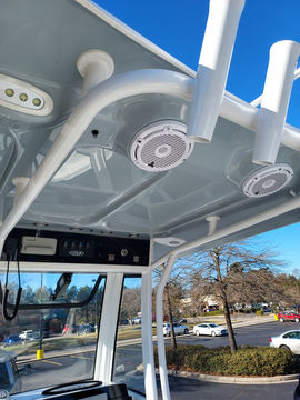 Boat interior with speakers and controls; bright day, clear blue sky