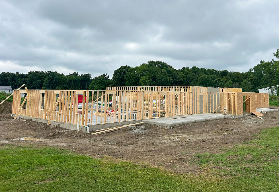 Wooden frame of a house under construction on a concrete base.