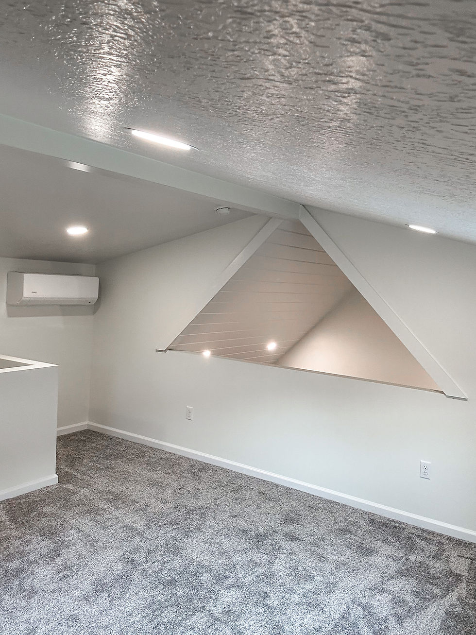 Renovated attic room with sloped ceilings and carpet