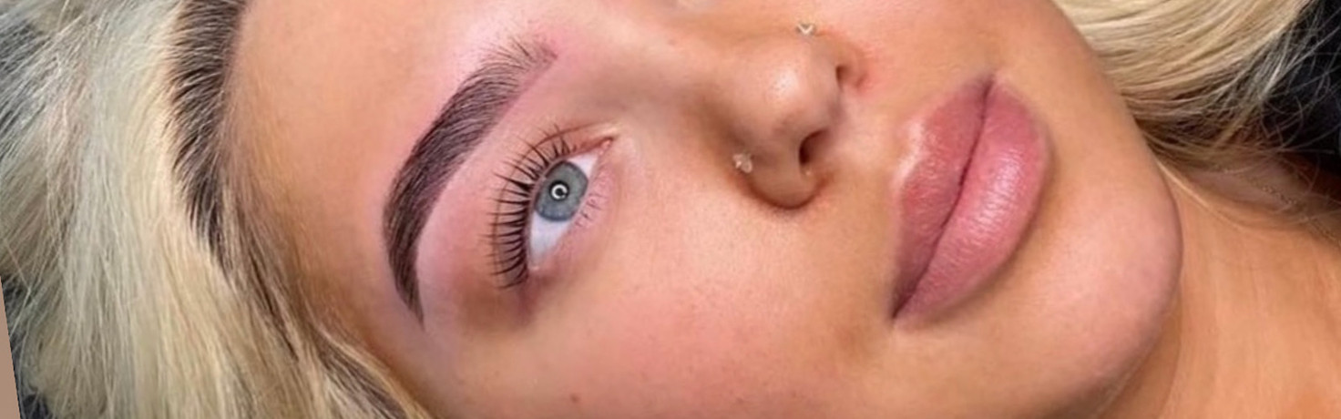 Close-up of a woman's face with HD Brows, makeup and blue eyes.