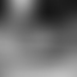 Hands examining old photos and writing notes, black and white image. A pen and papers are visible, evoking nostalgia and curiosity.